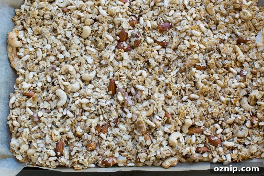 Homemade Low Sugar Granola: Crunchy Morning Recipe 5 Ingredients for homemade granola scattered on a baking tray ready for the oven