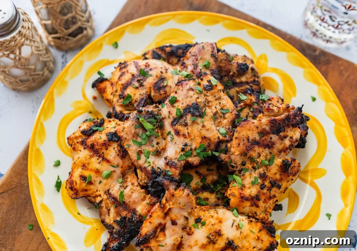 Greek Yogurt Chicken Marinade for Juicy Grilled Chicken 2 Chicken on a serving dish with garnish, and more sides surrounding.