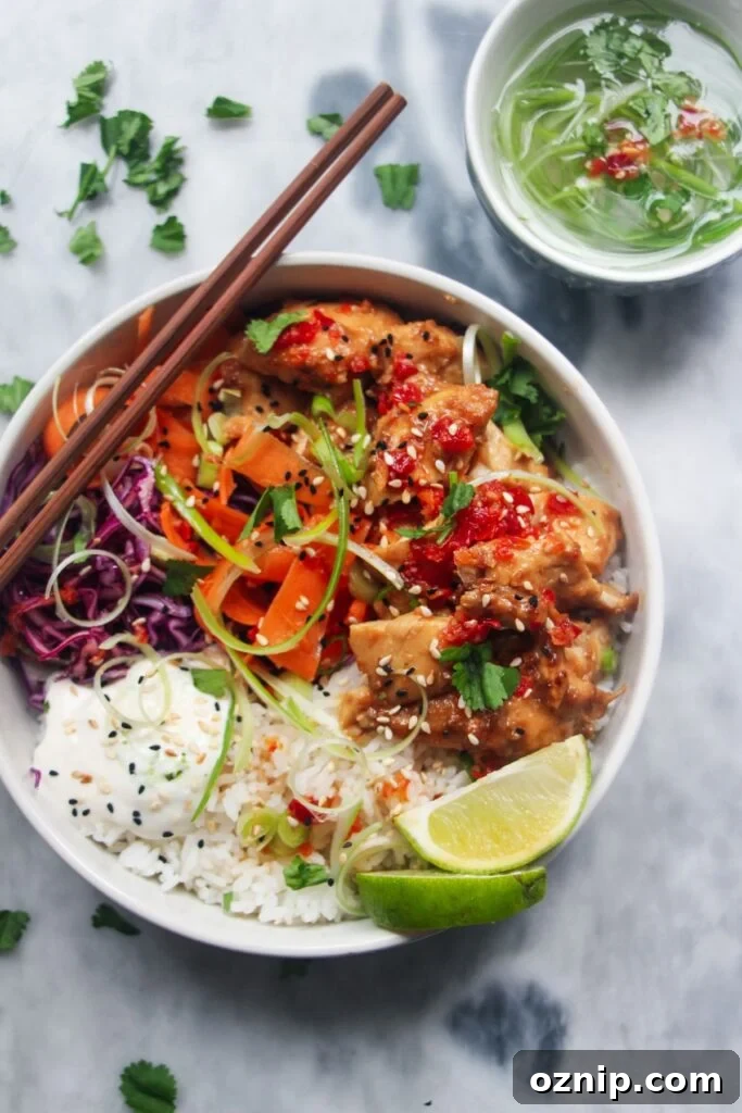 Grilled chicken poke bowl on a grey marble background.