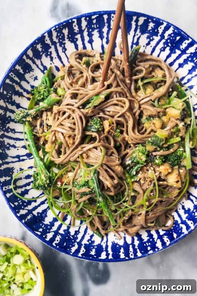 Sesame soba noodles with cucumber and broccolini in a bowl.