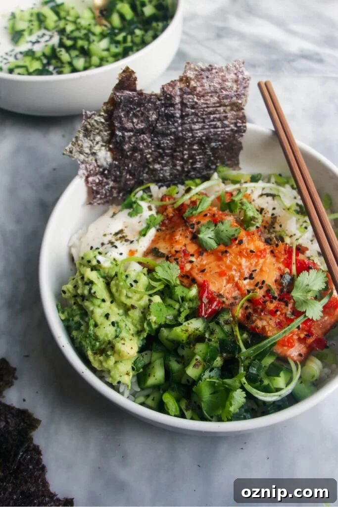 White bowl filled with colourful vegetables and a salmon fillet.