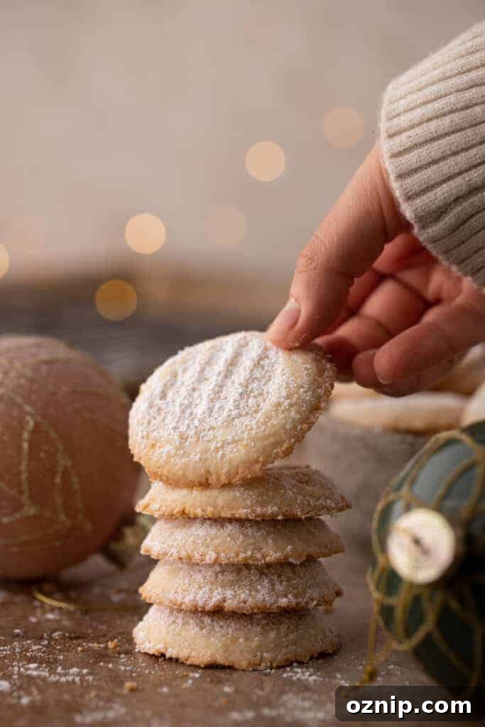 Melting Moments Cookies Recipe That Melt in Your Mouth 11 a stack of melting moments cookies with the top one being lifted up by a hand