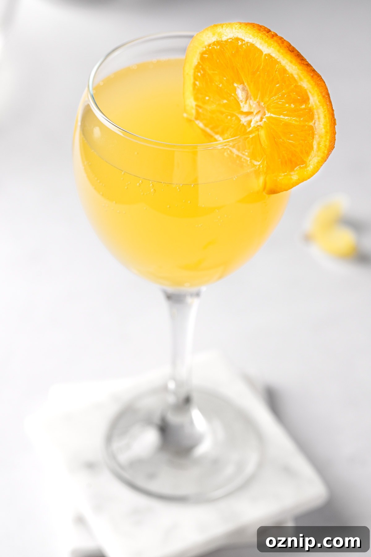 An agua de valencia cocktail, garnished with an orange slice.