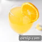 An agua de valencia cocktail, garnished with an orange slice.
