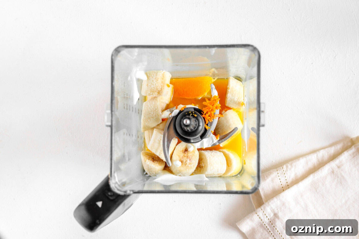 Ingredients for orange fruit smoothies in a blender.