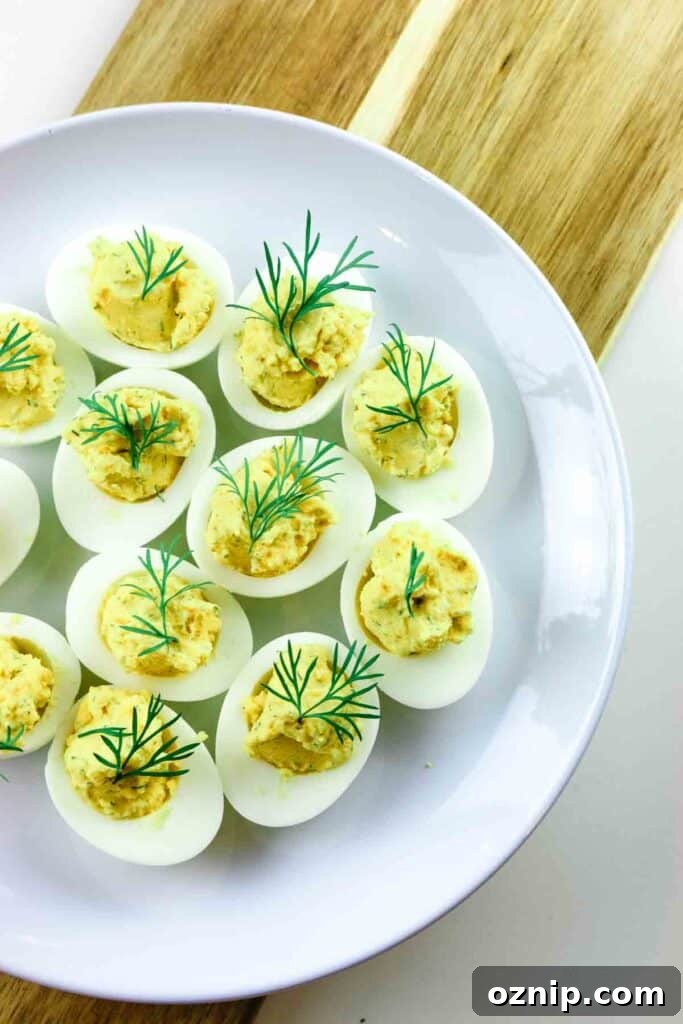 Classic Deviled Eggs Recipe for Parties 2 Deviled eggs on a platter and wooden cutting board.