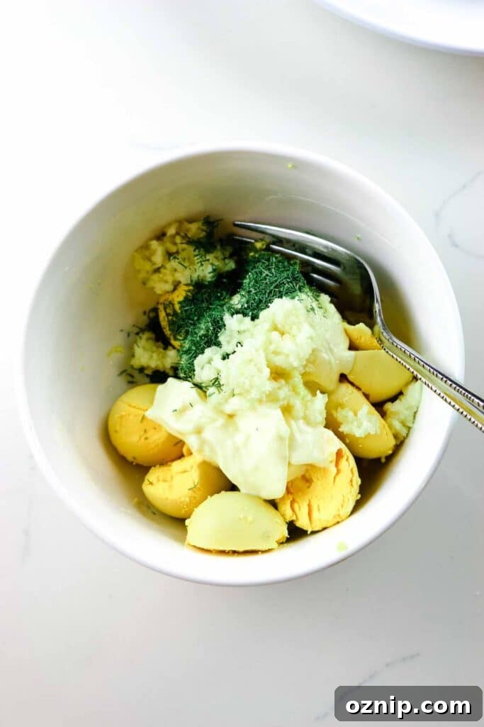 Classic Deviled Eggs Recipe for Parties 6 Egg yolks, mayonnaise, fresh garlic, and dill in a small ramekin.