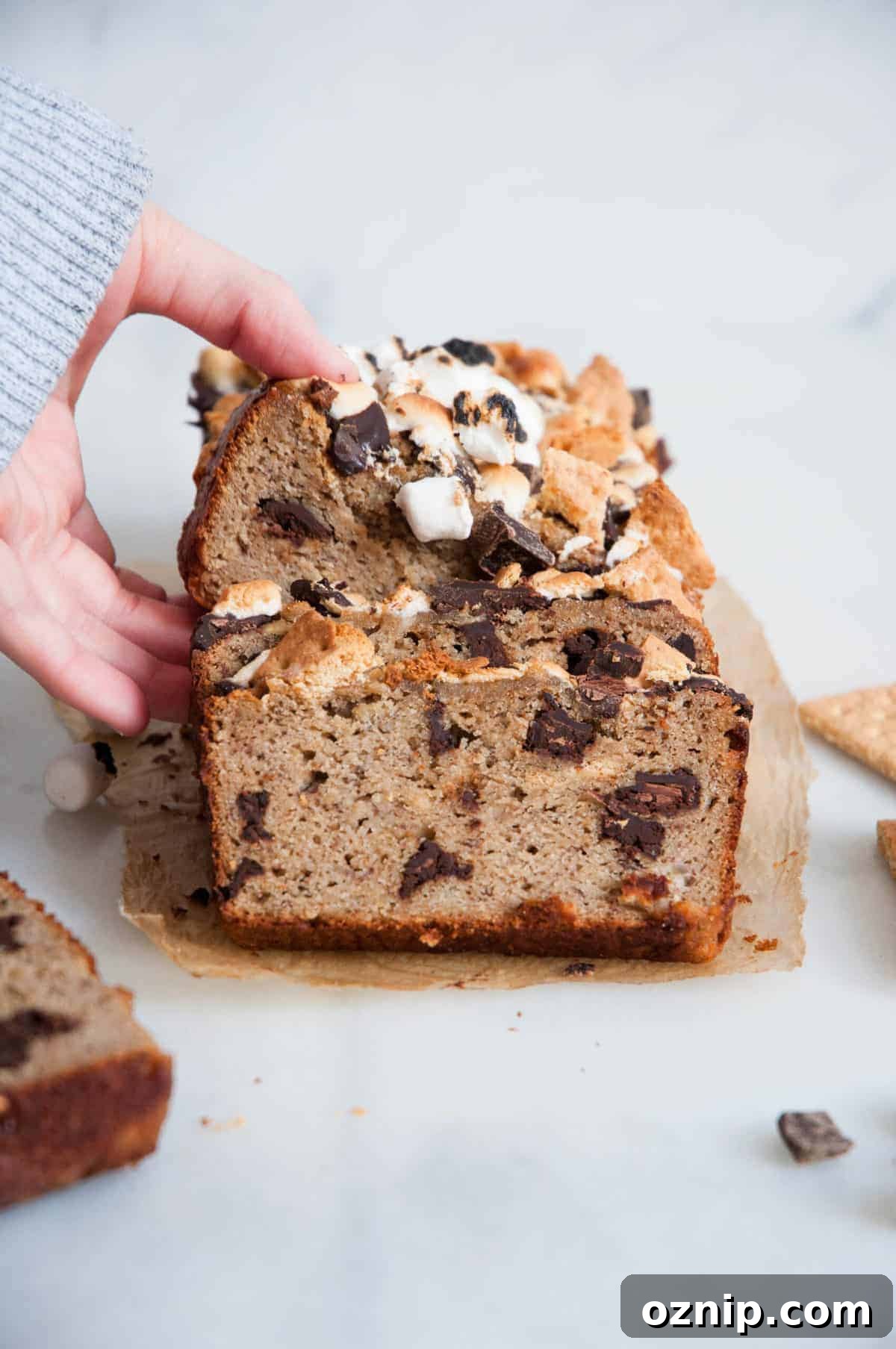 hand grabbing slice of smores banana bread