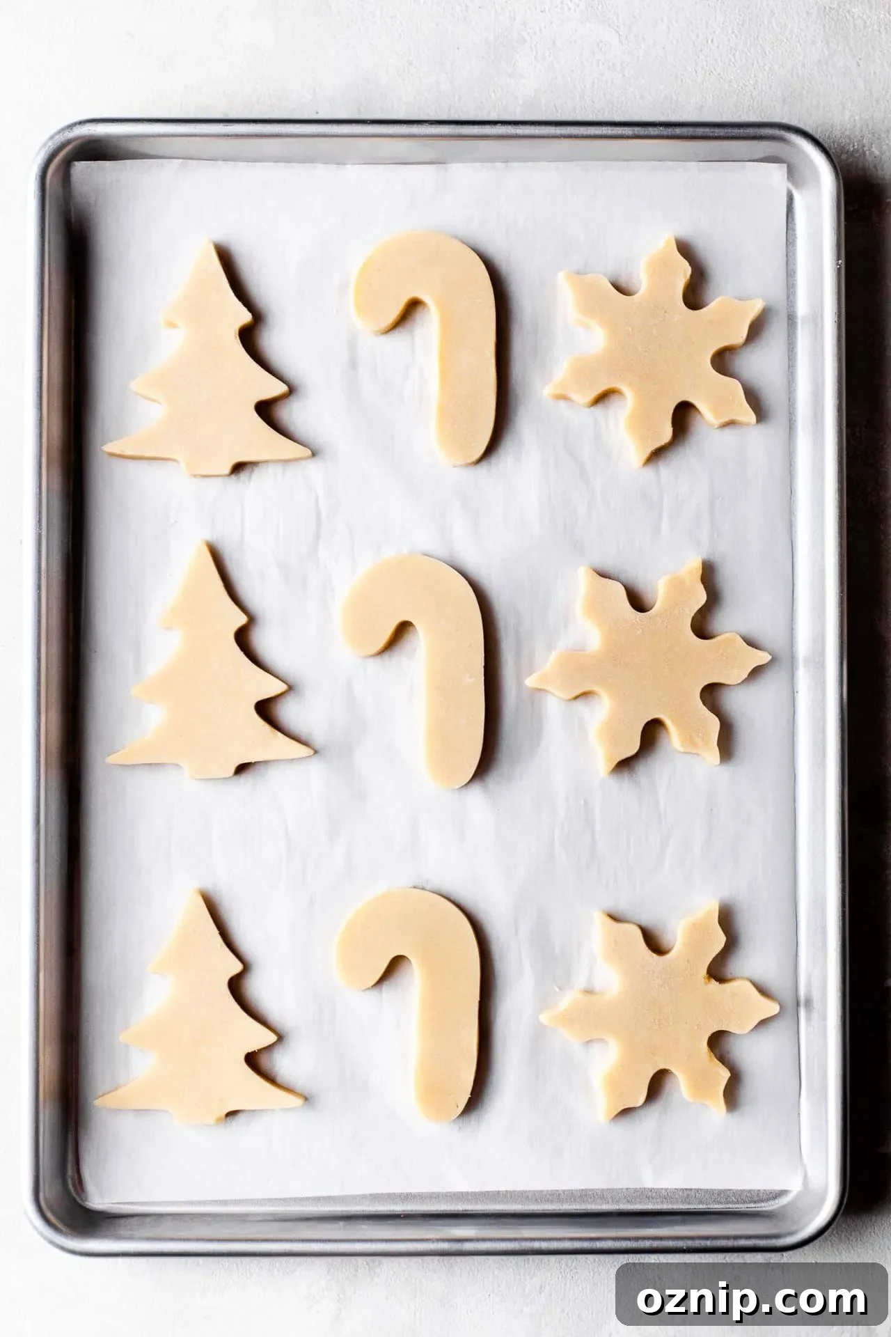 cut out sugar cookies on parchment lined baking sheet