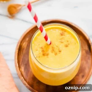 5-ingredient banana pumpkin smoothie in a glass with a red striped straw.