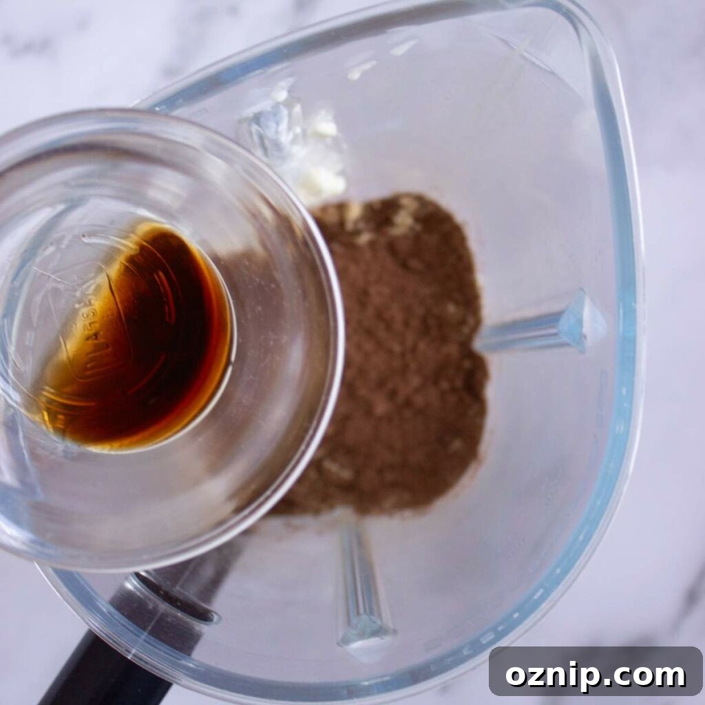 Low Carb Sugar Free Protein Pudding Recipe 9 Vanilla extract is being poured into a blender.