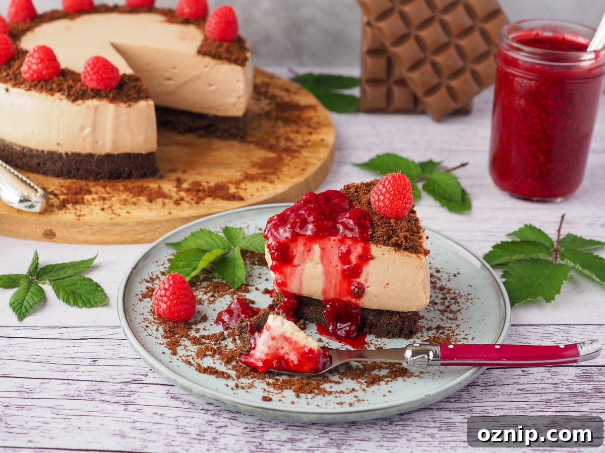 Slice of cheesecake with fresh raspberries and raspberry compote.