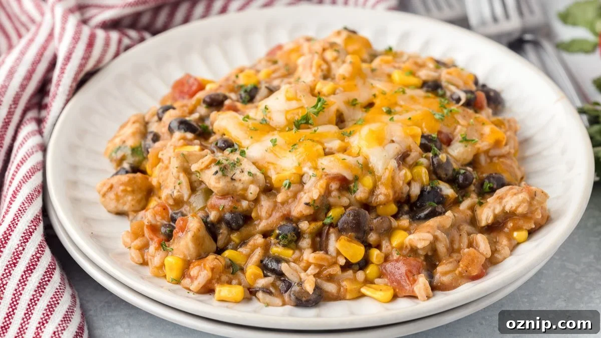 Mexican chicken and rice casserole served on a white plate with a red and white striped napkin on the side.