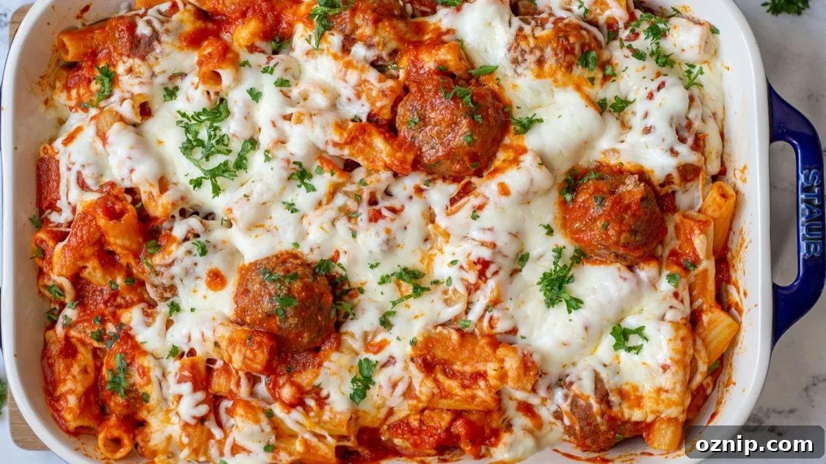 Baked ziti with meatballs in a blue casserole dish.