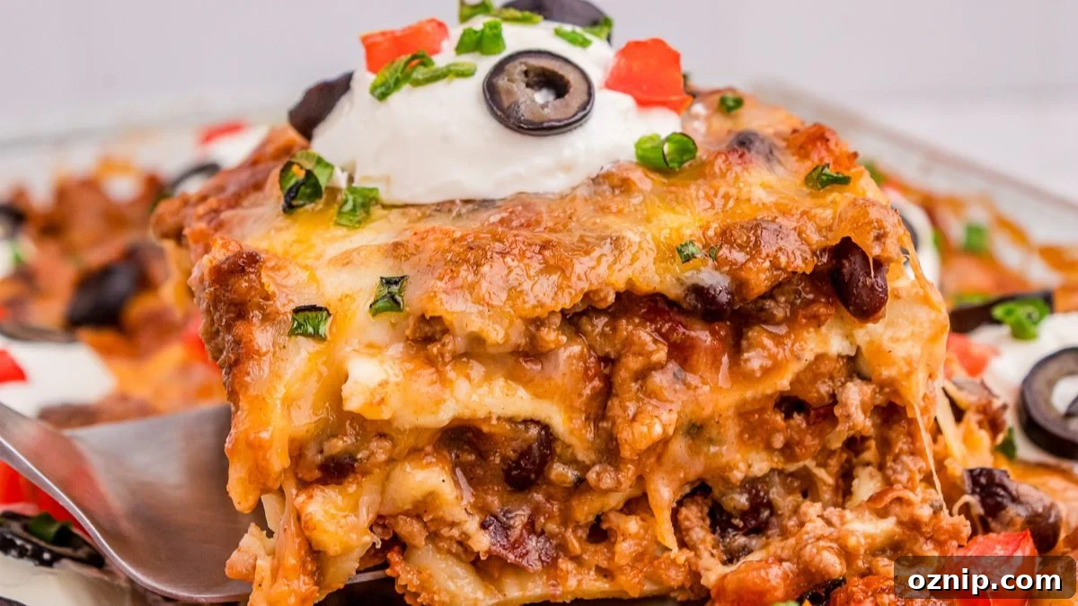 Mexican Lasagna held up by a serving spoon ready to be enjoyed.