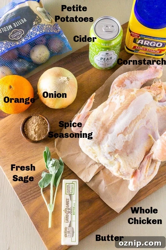 Whole chicken, potatoes, onion, orange, sage, butter, seasonings. hard cider, and cornstarch on a cutting board.