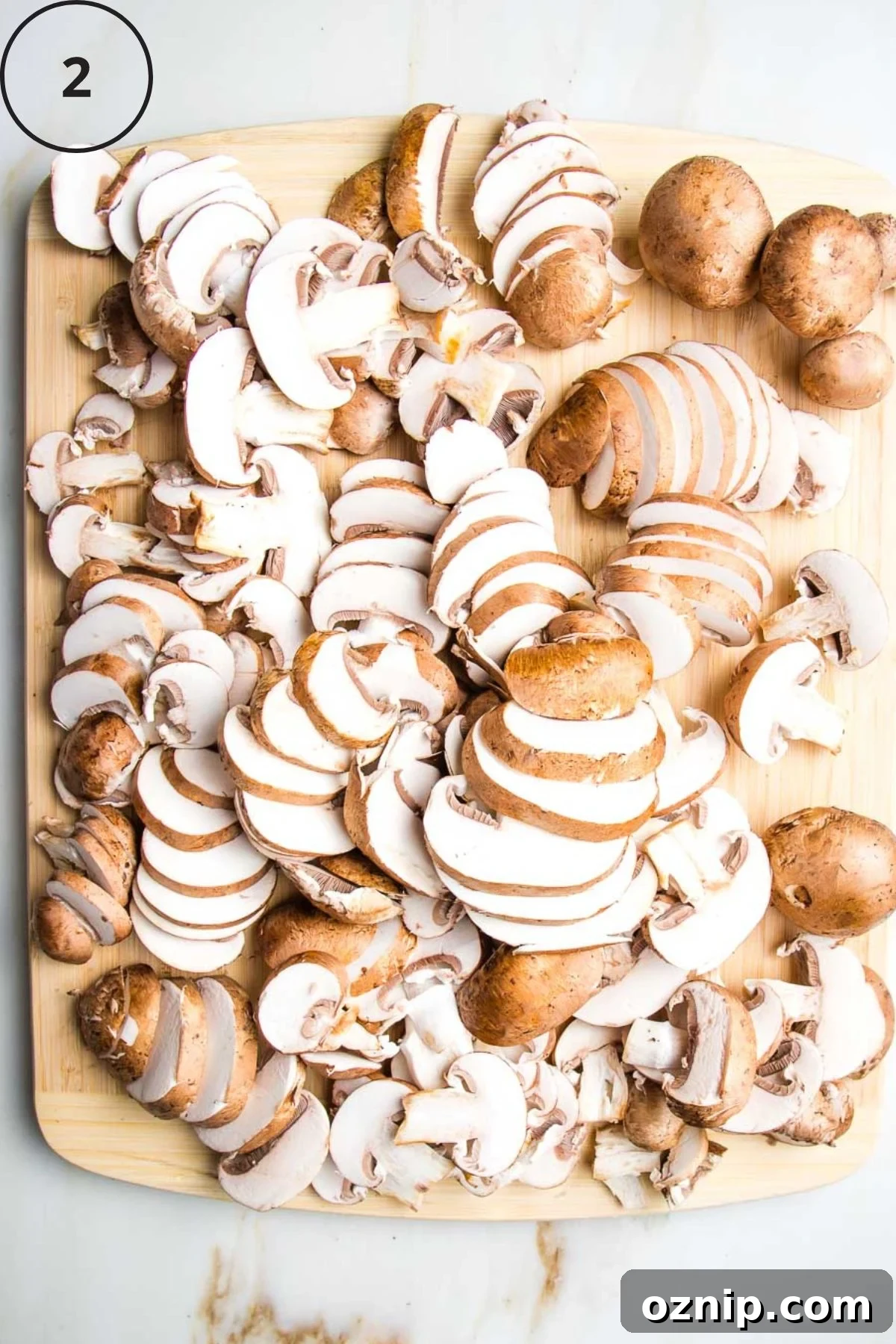 Sliced portobello mushrooms on a wooden board.