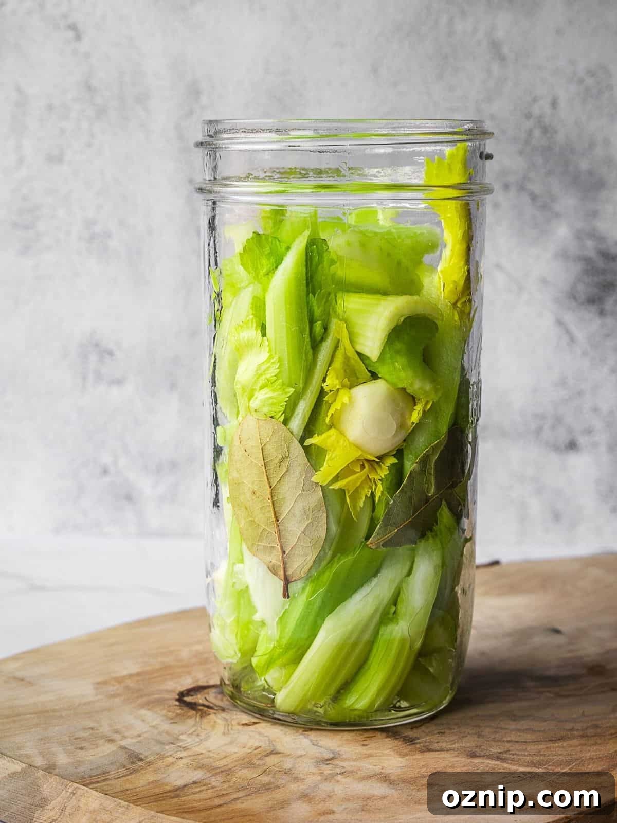 Celery, garlic and bay leaves in a tall mason jar.