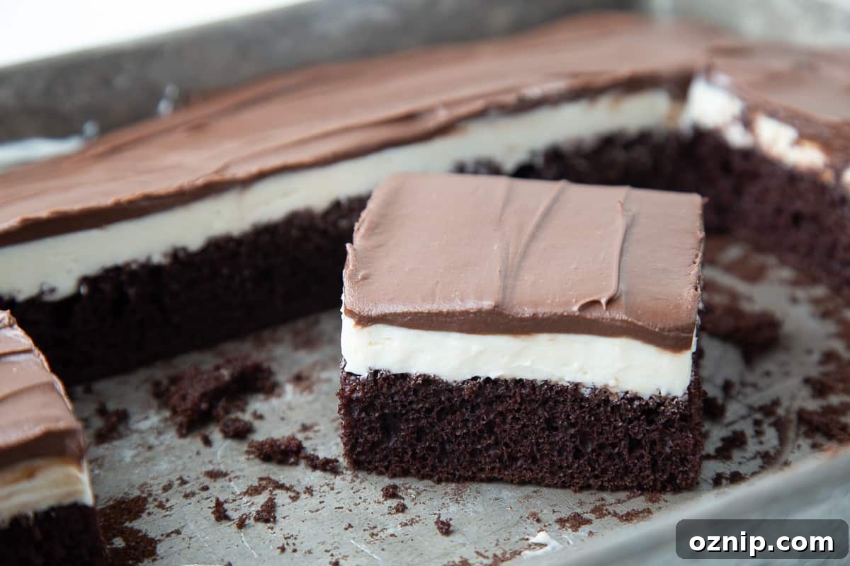 Slice of ding dong cake in a cake pan, surrounded by more cake.