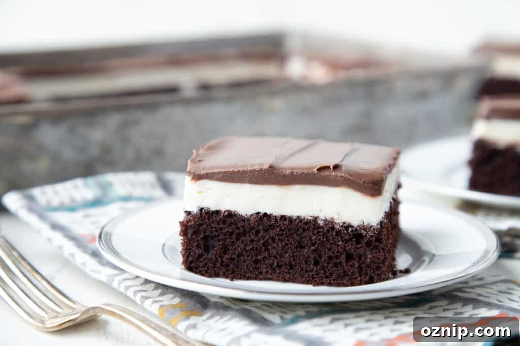 Slice of ding dong cake on a white plate with a colorful napkin underneath and a fork nearby.